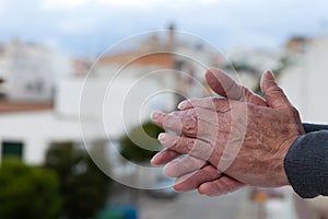 Closeup shot of an old man's hand applause to medical personnel in Spain