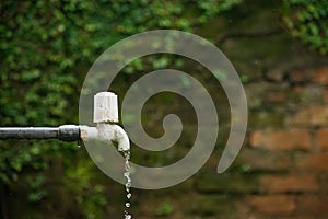 Closeup shot of an old outdoor water faucet and water drops leaking from it