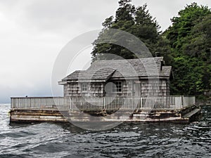 Closeup shot of an old wooden abandoned house in the sea during gloomy weather