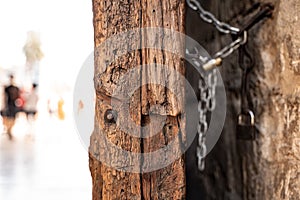 Closeup shot of an old wooden door and rusted lock chain detail