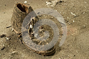 Closeup shot of an old worn out dirty boot on the ground