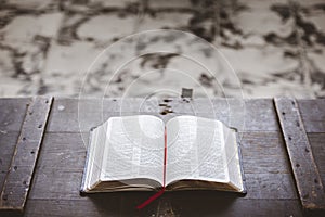 Closeup shot of an open bible on a wooden box with a blurred background