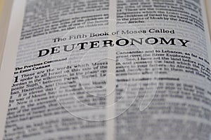 Closeup shot of open page with the fifth book of moses called deuteronomy text