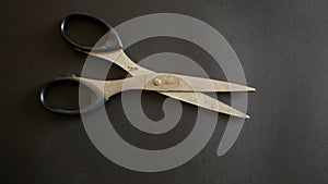 Closeup shot of a pair of scissors on a black surface