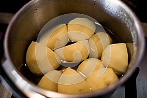 Closeup shot of peeled potatoes cooking in a saucepan