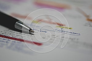 Closeup shot of a pen on a paper with handwritten notes