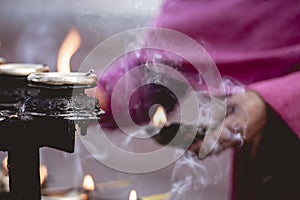 Closeup shot of a person lighting candles with a blurred background photo