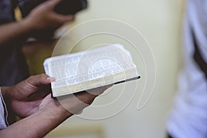 Closeup shot of a person reading the bible with a blurred background