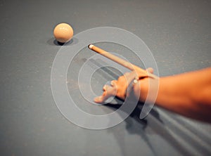 Closeup shot of a person& x27;s hand aiming on a white snooker ball with a cue. Billiard concept.
