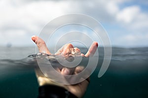 Closeup shot of a person's hand clenched in a fist in the water