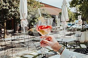 Closeup shot of a person's hand holding a glass of cocktail