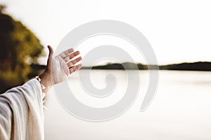 Closeup shot of a person wearing a biblical robe with a hand up and a blurred background