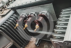 Closeup shot of 3-phase distribution transformer Bushings with porcelain insulator