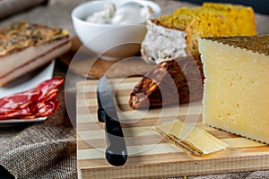 Closeup shot of a piece of parmesan cheese Ventricina sausage and bread on a cutting board