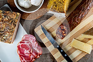 Closeup shot of a piece of parmesan cheese Ventricina sausage and bread on a cutting board