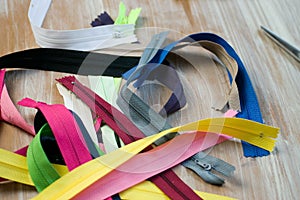 Closeup shot of a pile of colorful zips on a wooden surface