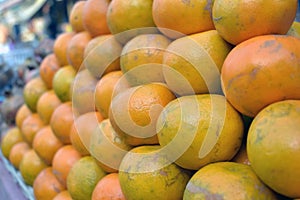Closeup shot of a pile of fresh oranges in a market place