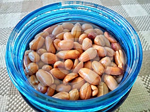 Closeup shot of a pile fried peanut in a blue jar photo