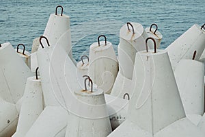 Closeup shot of the pile of white marine concrete tetrapods near the sea