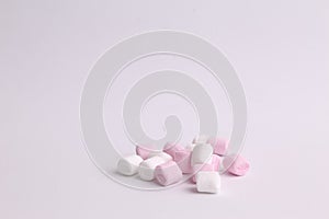 Closeup shot of pink and white mini marshmallows on a white background photo