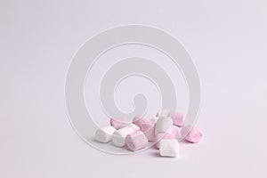 Closeup shot of pink and white mini marshmallows on a white background