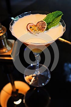 Closeup shot of a Porn star martini cocktail with a passion fruit and a mint leaf on top