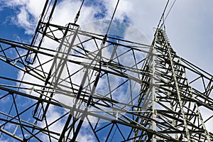 Closeup shot of a powerline with electric wires against a blue sky on a sunny day