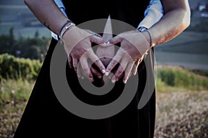 Closeup shot of a pregnant woman with her belly exposed and a man holding her from behind