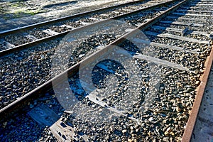 Closeup shot of a railway road, rails and cross ties on a sunny day