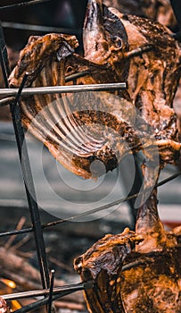 Closeup shot of raw lamb ribs on a traditional circular grill, being cooked with fire