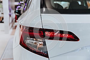 Closeup shot of a rear light of a modern white car in the salon