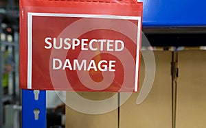 Closeup shot of red text sign SUSPECTED DAMAGE with blur background