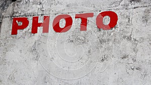 Closeup shot of a ref "PHOTO" writing on a concrete wall