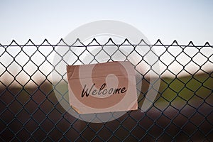 Closeup shot of refugees welcome sign on a metallic wired fence