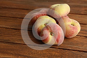 Closeup shot of ripe Paraguayan peach on a wooden surface photo