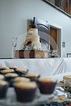 Closeup shot of rose-shaped wedding cupcakes with an appetizing cake decorated with roses