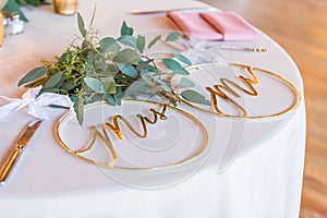 Closeup shot of round ring-shaped golden wedding decorations with writings \