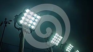 A closeup shot of a row of powerful floodlights standing tall against a dark sky