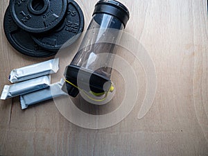 Closeup shot of rubberized discs and fitness bars on a wooden background