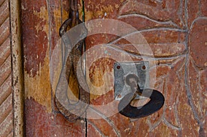 Closeup shot of the rusty door handle and the door lock  with the key installed in it