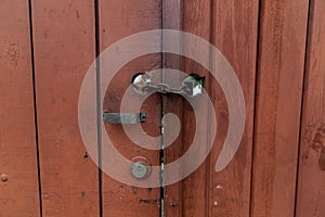 Closeup shot of a rusty lock chain on a closed wooden rustic door