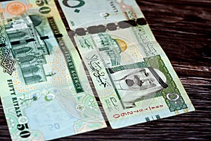 Closeup shot of the Saudi Arabia 50 SAR one hundred riyals cash banknotes on a wooden surface