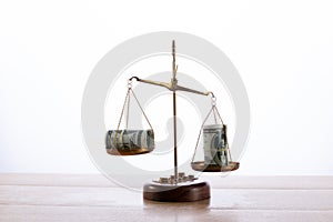 Closeup shot of scales with dollar banknotes on it - concept of justice