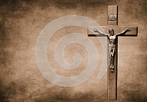 Closeup shot of a Sepia-toned crucifix with the body of Christ on a large background