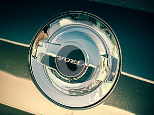 Closeup shot of a shiny silver fuel cap on a car