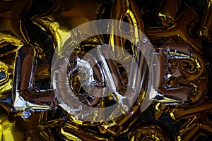 Closeup shot of silver balloons forming the word LOVE among other golden ones