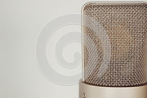 Closeup shot of a silver professional studio condenser microphone  on a white background