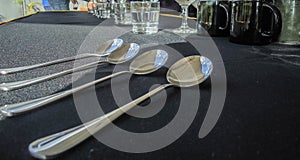 Closeup shot of silver spoons on a black tablecloth