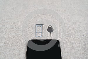 Closeup shot of Sim card tray, eject tool, smartphone