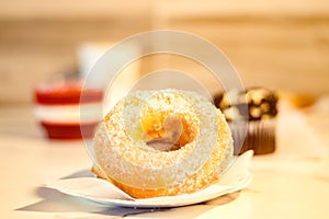 Closeup shot of a single sugar donut placed on a white paper on an isolated background